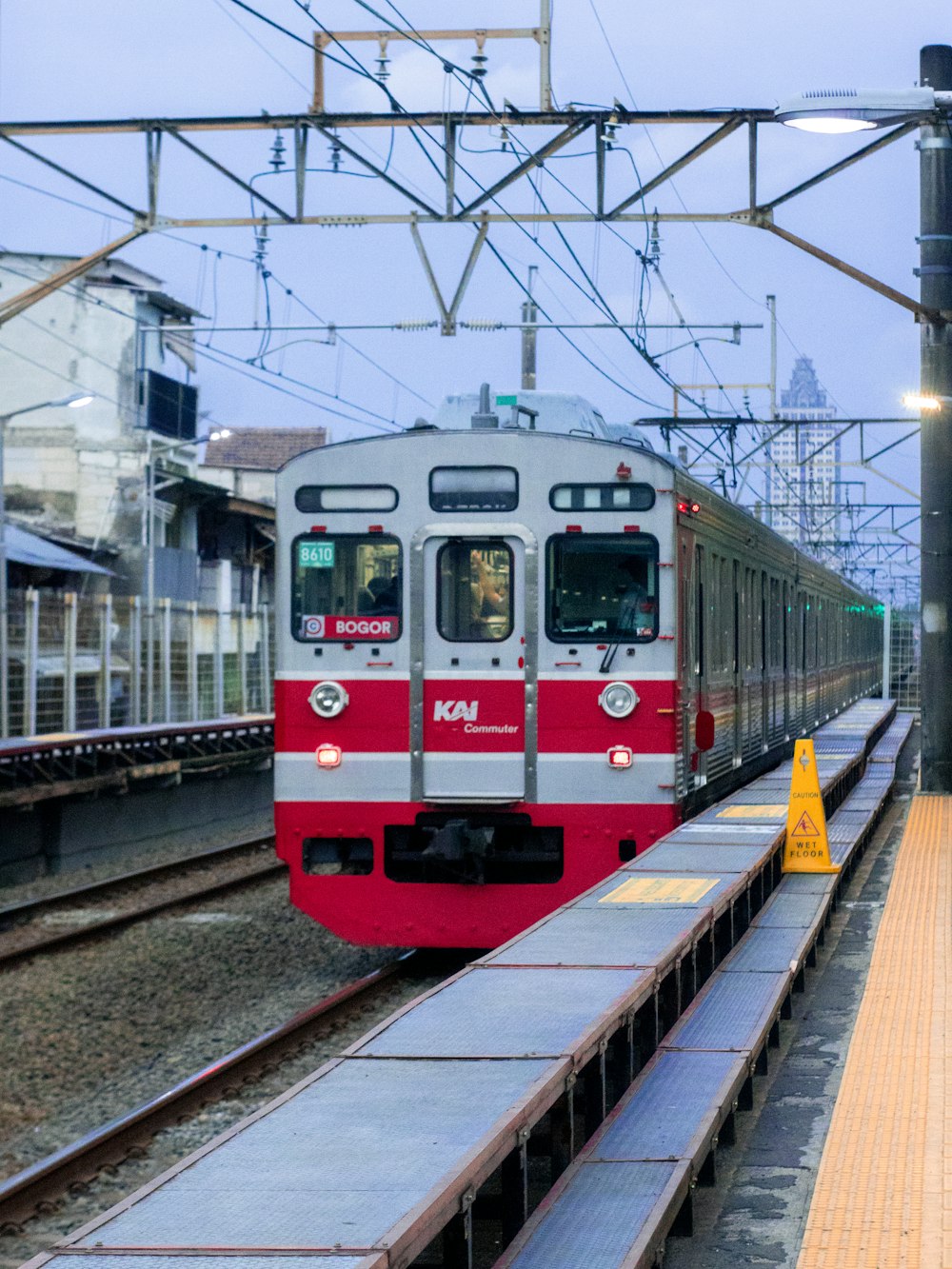 a red and white train pulling into a train station