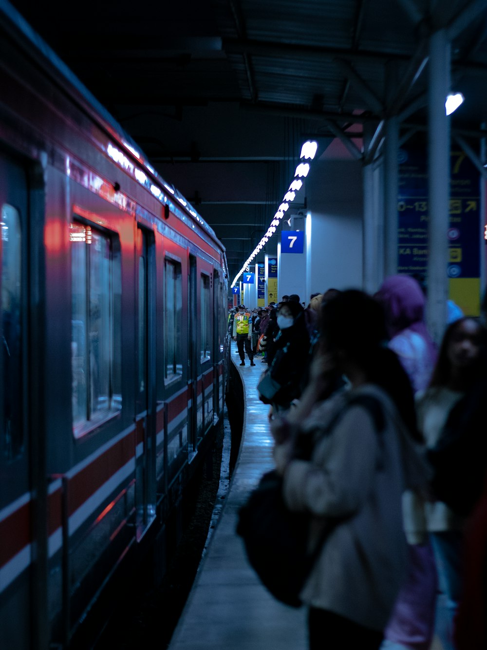 a group of people standing next to a train