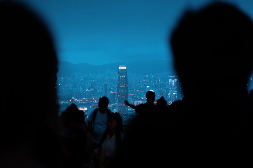 a group of people standing next to each other in front of a city