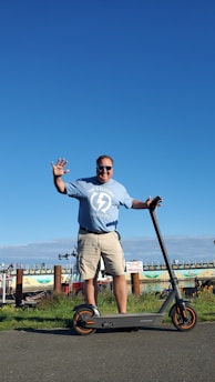 A happy person handing over keys of an electric scooter to another rider in a sunny urban setting