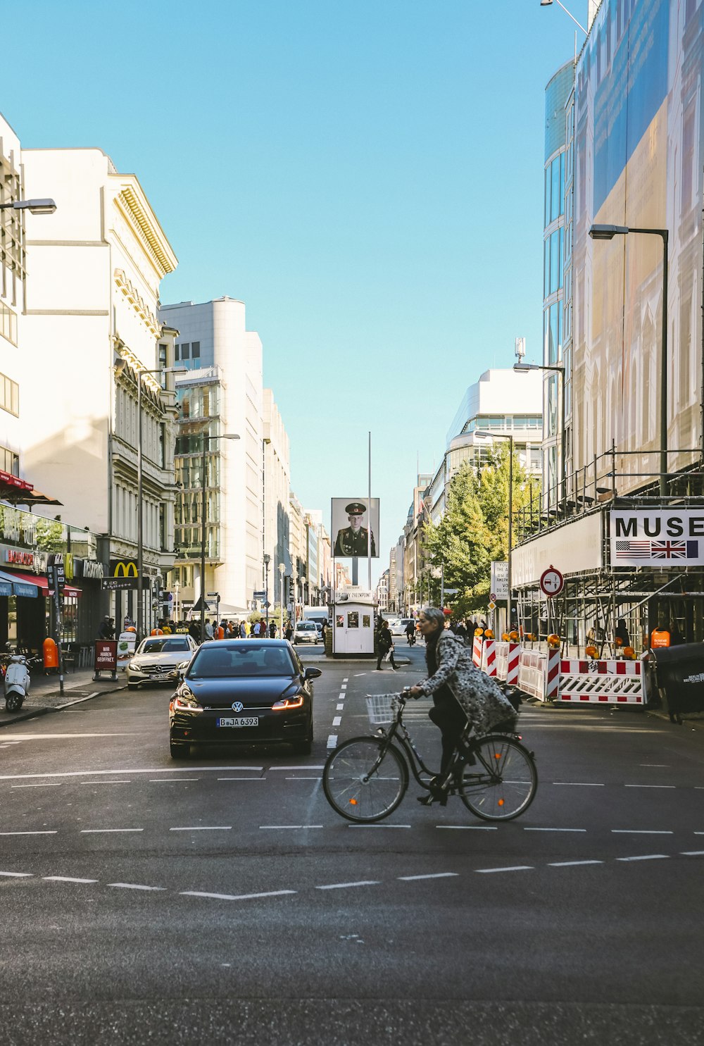 a man riding a bike down a street next to tall buildings