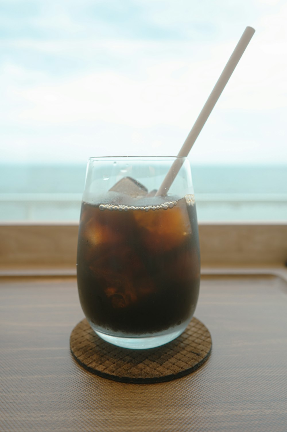 a glass of soda with a spoon in it