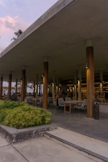 A welcoming pavilion-style outdoor seating area bathed in soft natural light with greenery around.