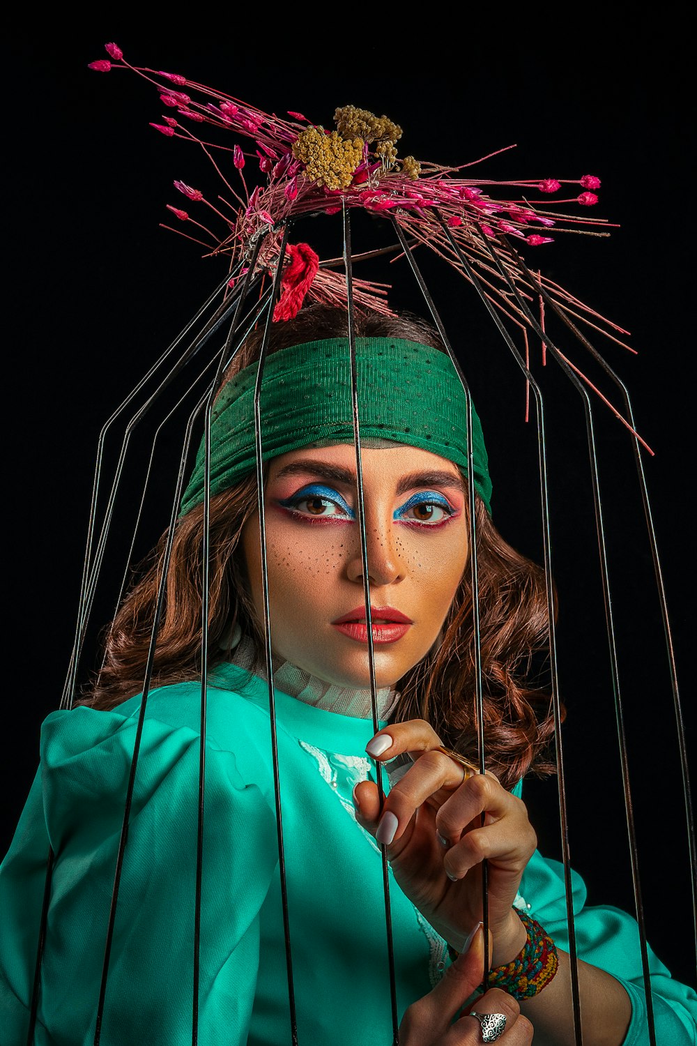 a woman with blue eyes is holding a birdcage