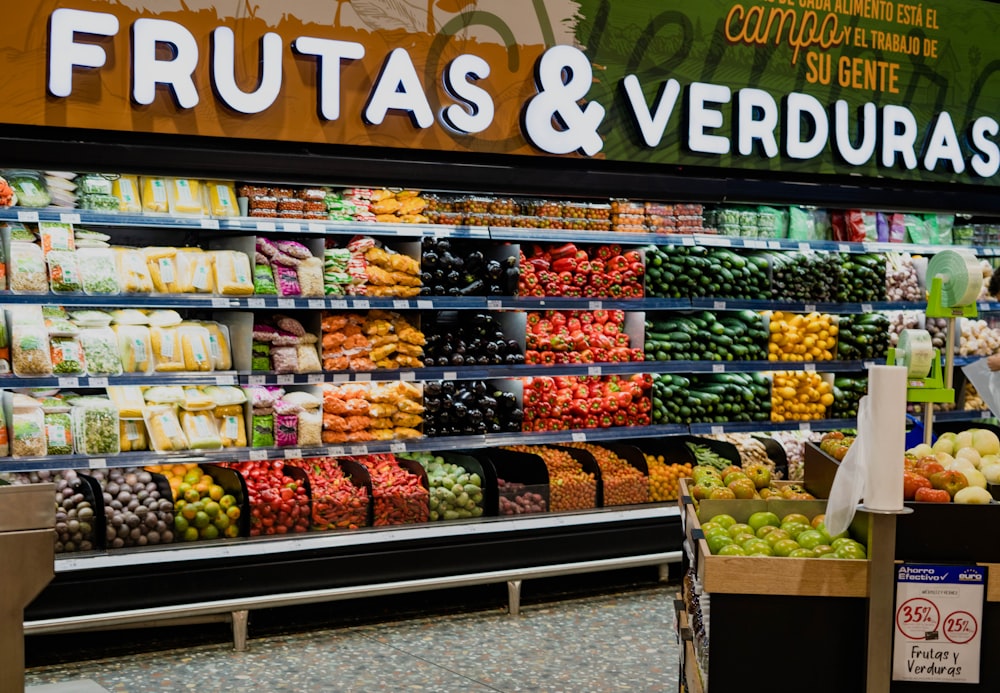 Una sección de productos agrícolas de una tienda de comestibles llena de frutas y verduras