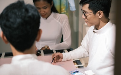 a man signing a document with a woman in the background