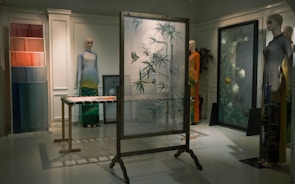 An elegant exhibition space showcasing unique art pieces and bespoke clothing.