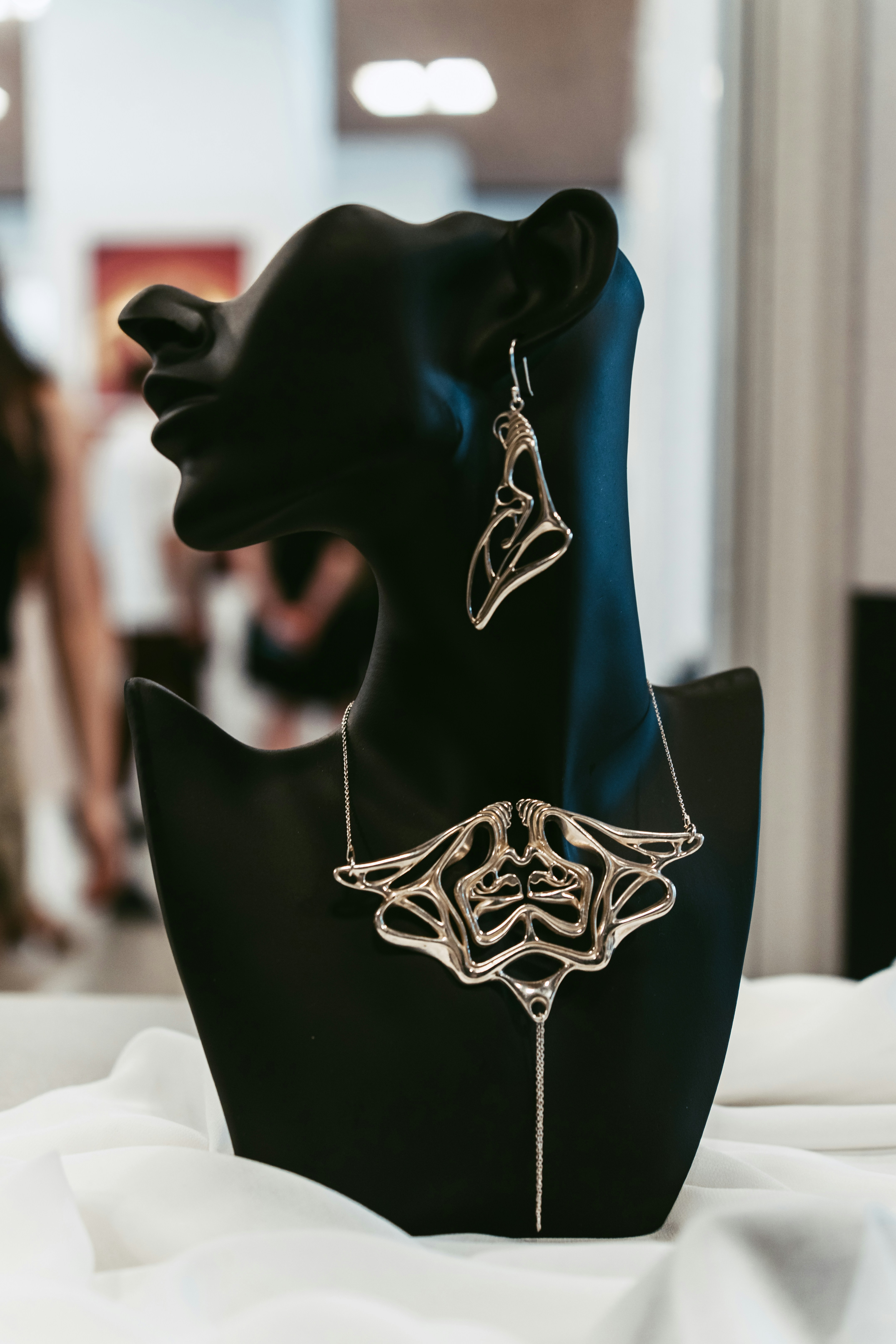 Conjunto de collar y pendientes de plata expuesto en un busto de maniquí.