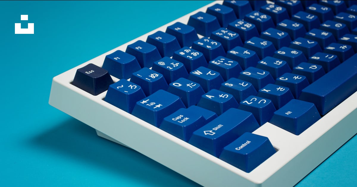 A blue and white computer keyboard on a blue surface photo – Free ...