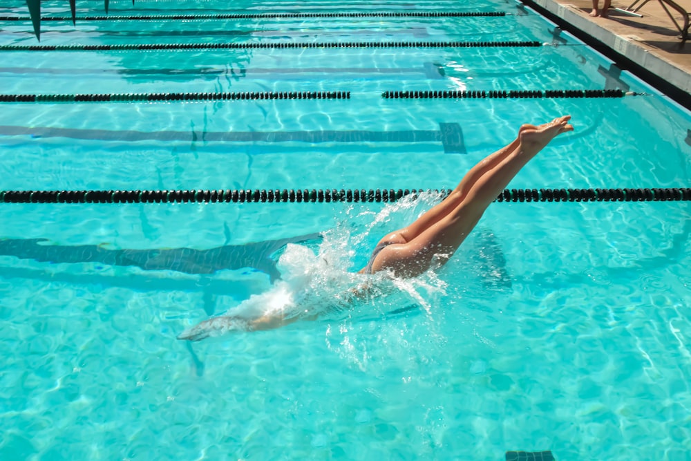 a woman is swimming in a swimming pool