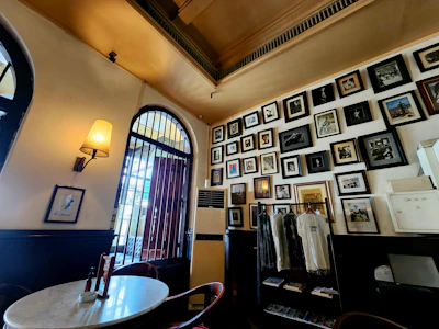 A cozy corner inside Elmora Atelier showcasing framed vintage memorabilia and fine art pieces.
