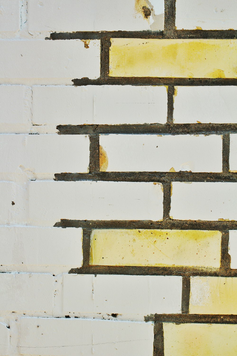 a close up of a brick wall with yellow paint