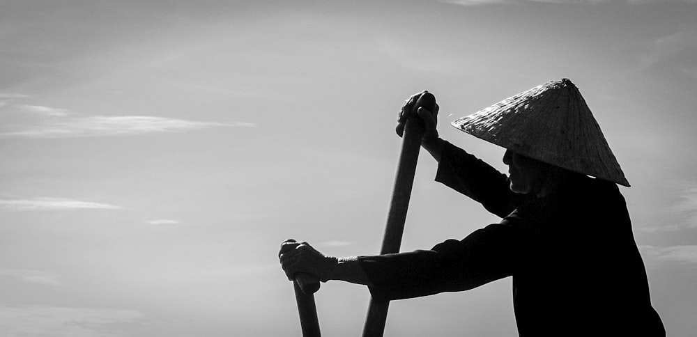 une photo en noir et blanc d’une personne tenant un bâton