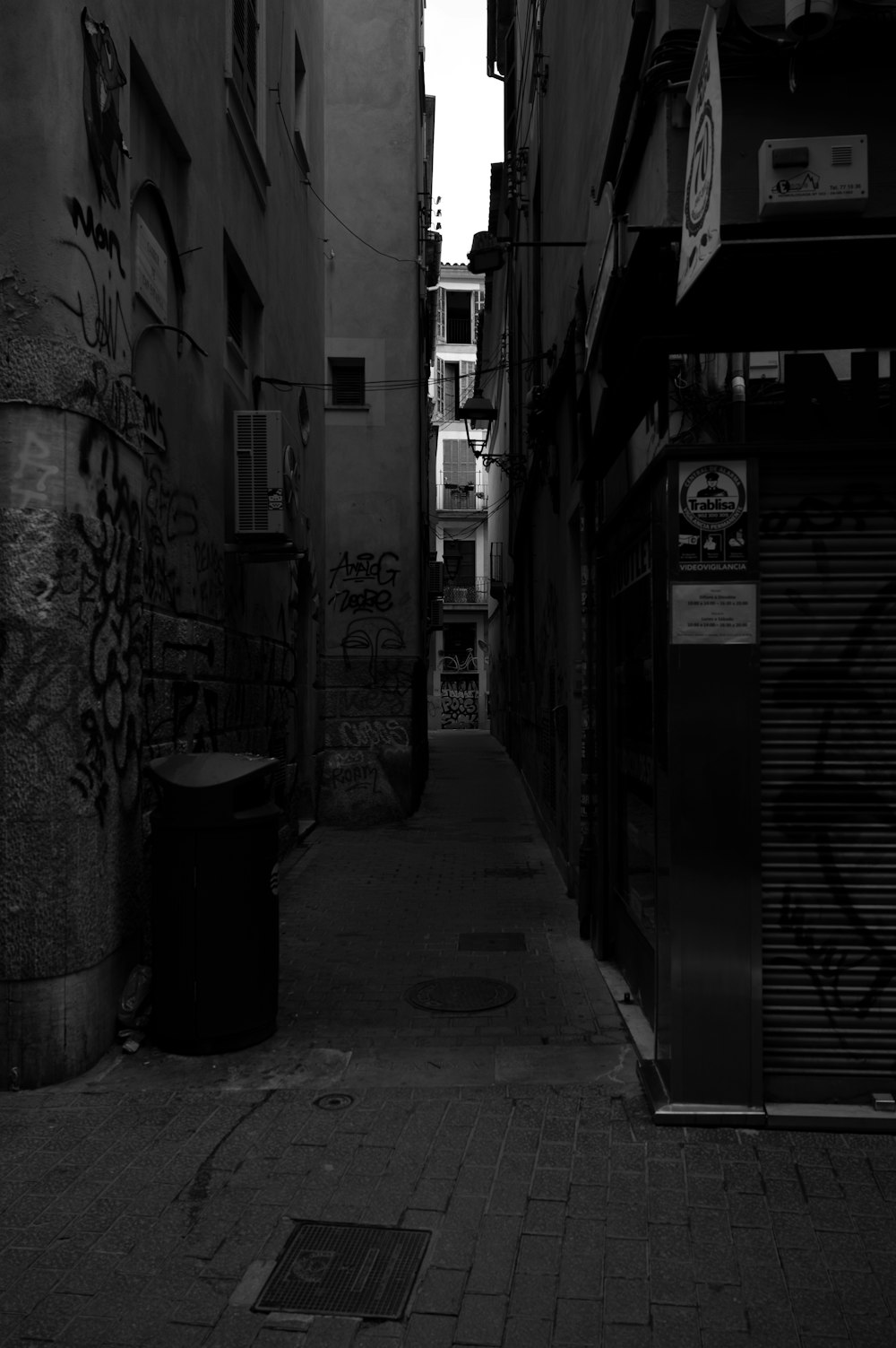 a narrow alley way with graffiti on the walls