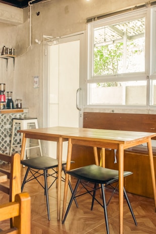A cozy café table set with maana’s minimalist wooden trays and menu holders in soft neutral tones.
