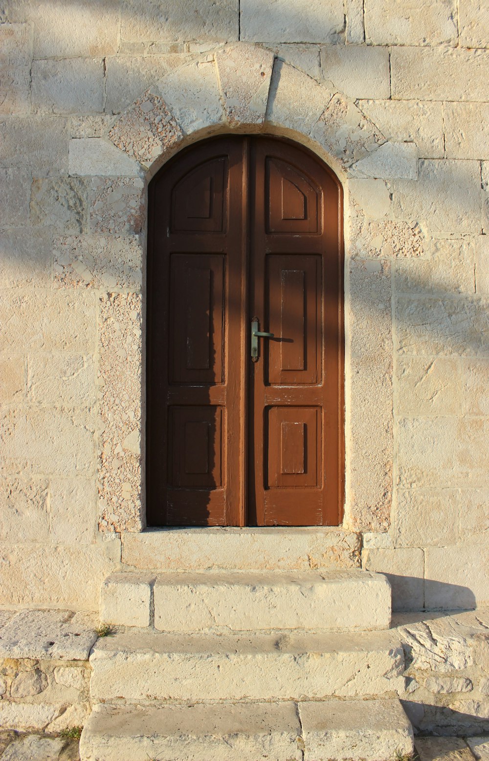 a brown door is open on a stone building
