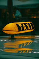 a yellow taxi sign sitting on top of a car