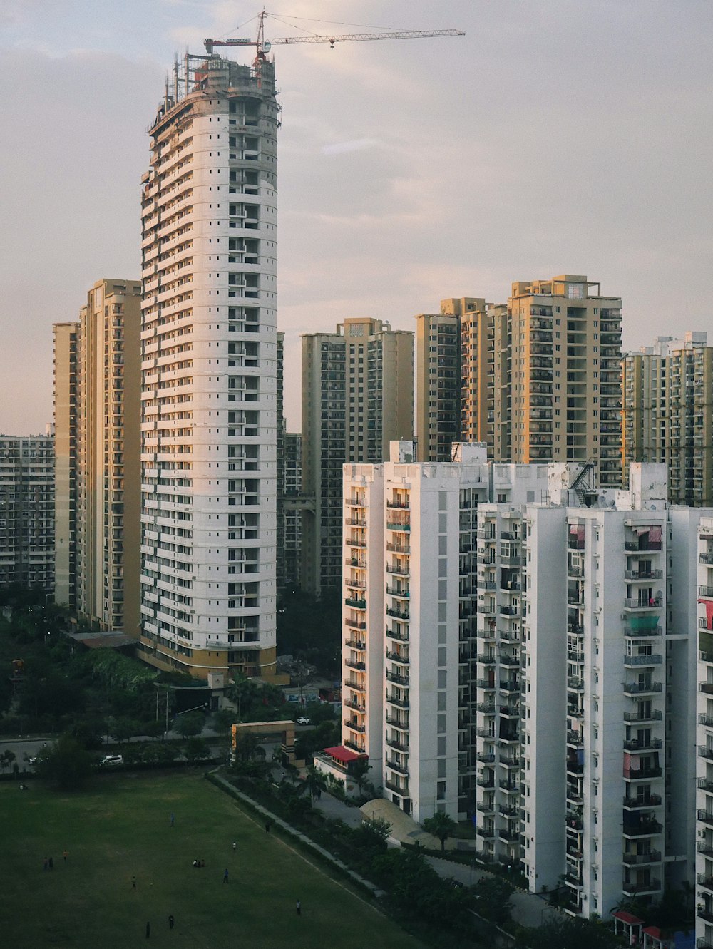 a group of tall buildings with a crane in the background