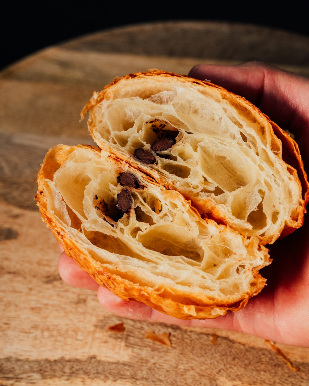 a person holding a piece of bread in their hand