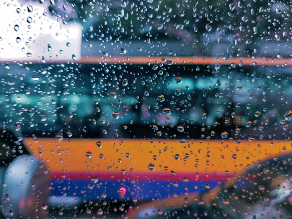 a view of a bus through a rain covered window