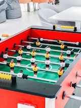 Group of happy customers playing foosball at a university event.