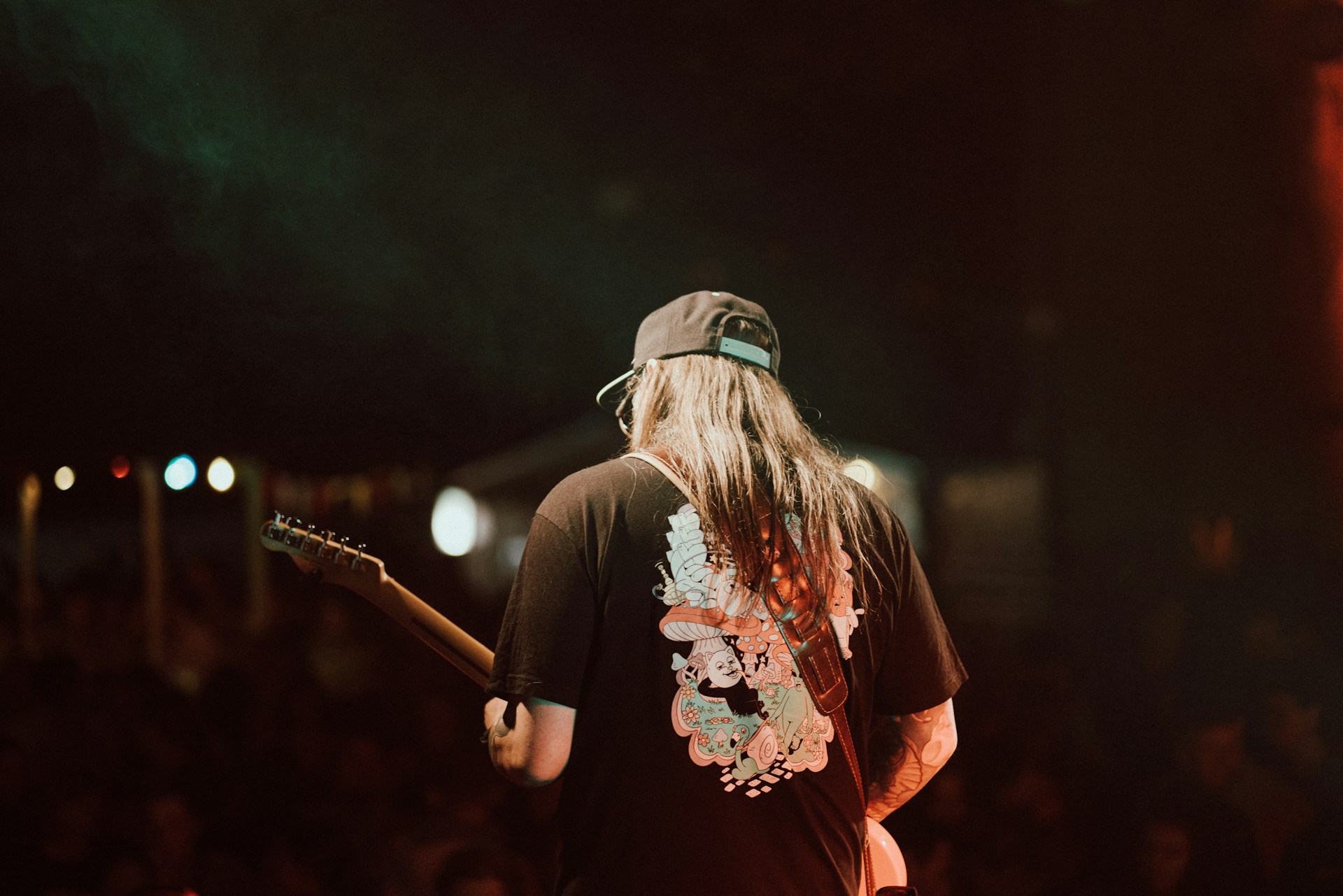 a man with long hair holding a guitar