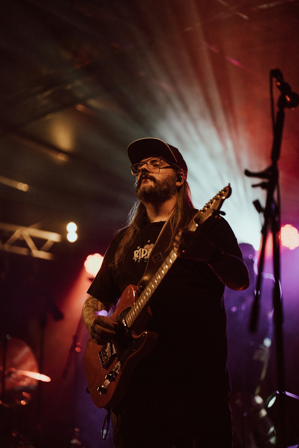 a man with long hair playing a guitar