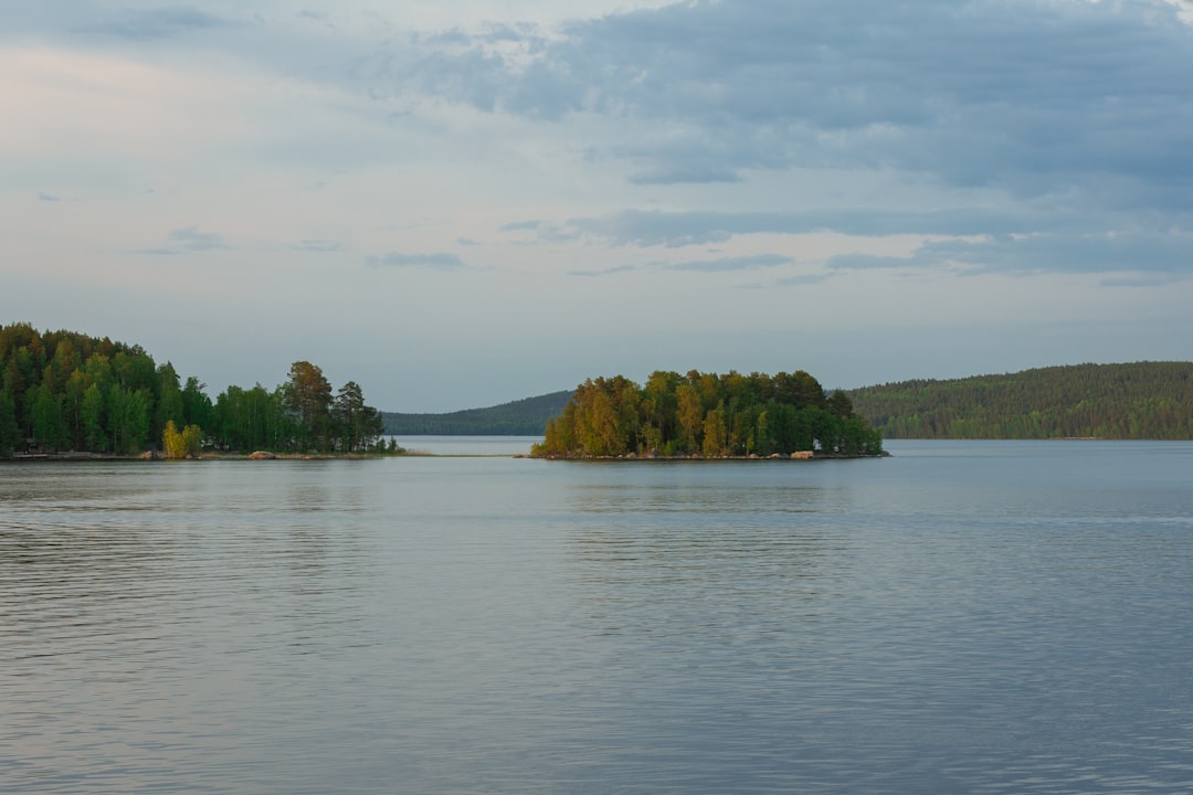 a large body of water surrounded by trees, Finnish lake with green islands