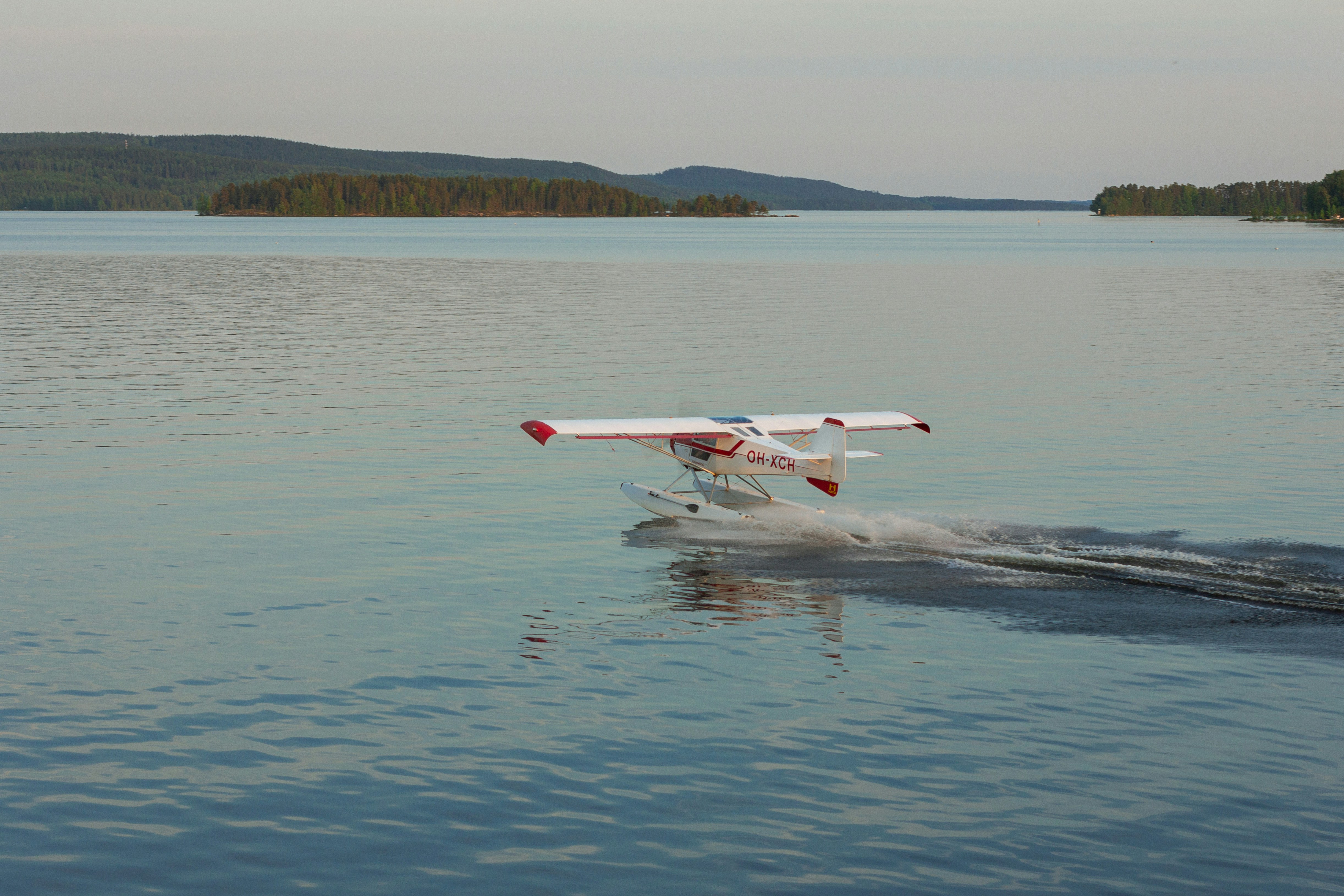 a small plane is flying low over the water, seaplane taking off the lake