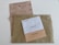 Three envelopes and a voting ballot are arranged on a flat surface. The largest envelope is brown with a text reading 'Elecciones Voto por Correo' and a stamp indicating it is urgent. On top of it, there are two smaller envelopes, one white labeled 'Diputados/as' and one beige labeled 'Senadores/as'. The voting ballot is partially visible beneath the envelopes, providing options for different political parties.
