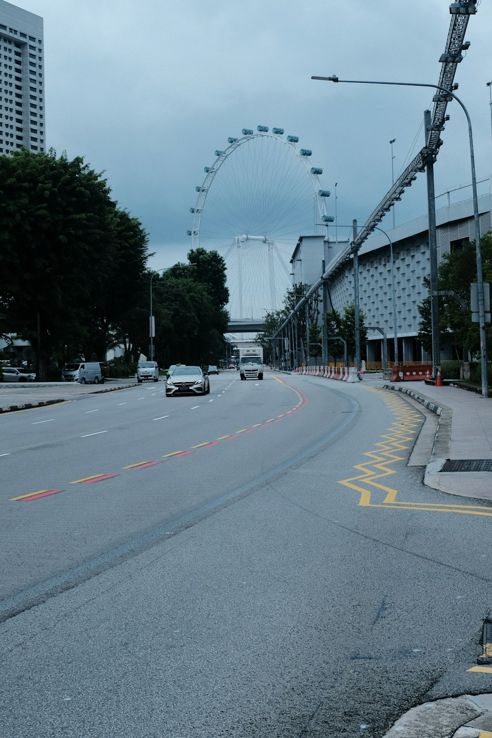 a city street with a ferris wheel in the background