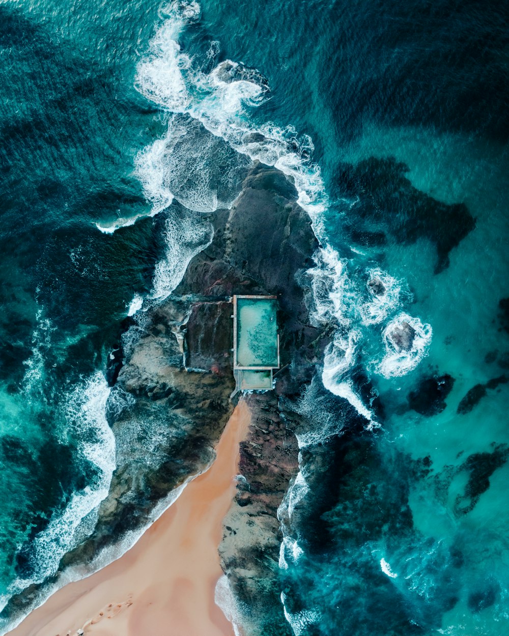 uma vista aérea de uma praia de areia e oceano