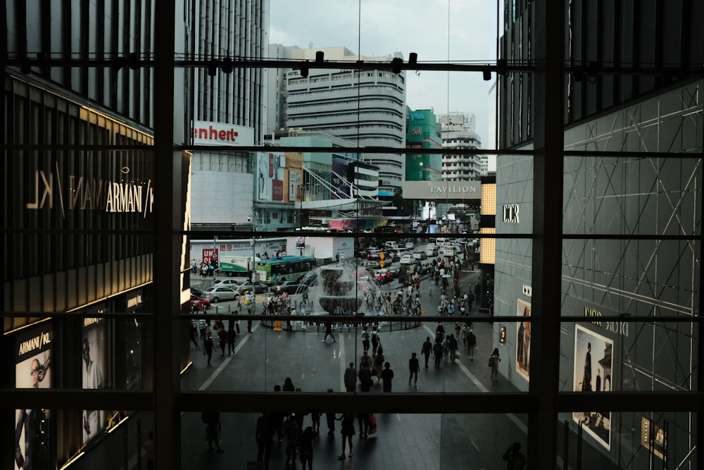 a group of people walking down a street next to tall buildings