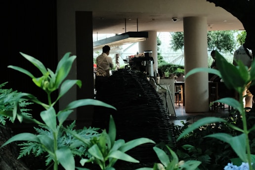 A lively coffee workshop where participants learn brewing techniques surrounded by lush greenery.