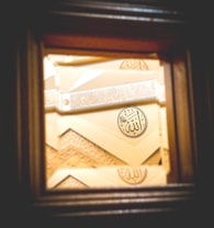 A detailed piece of Islamic geometric art featuring Arabic calligraphy. The artwork includes intricate patterns and a prominent circular motif with calligraphy in the center.