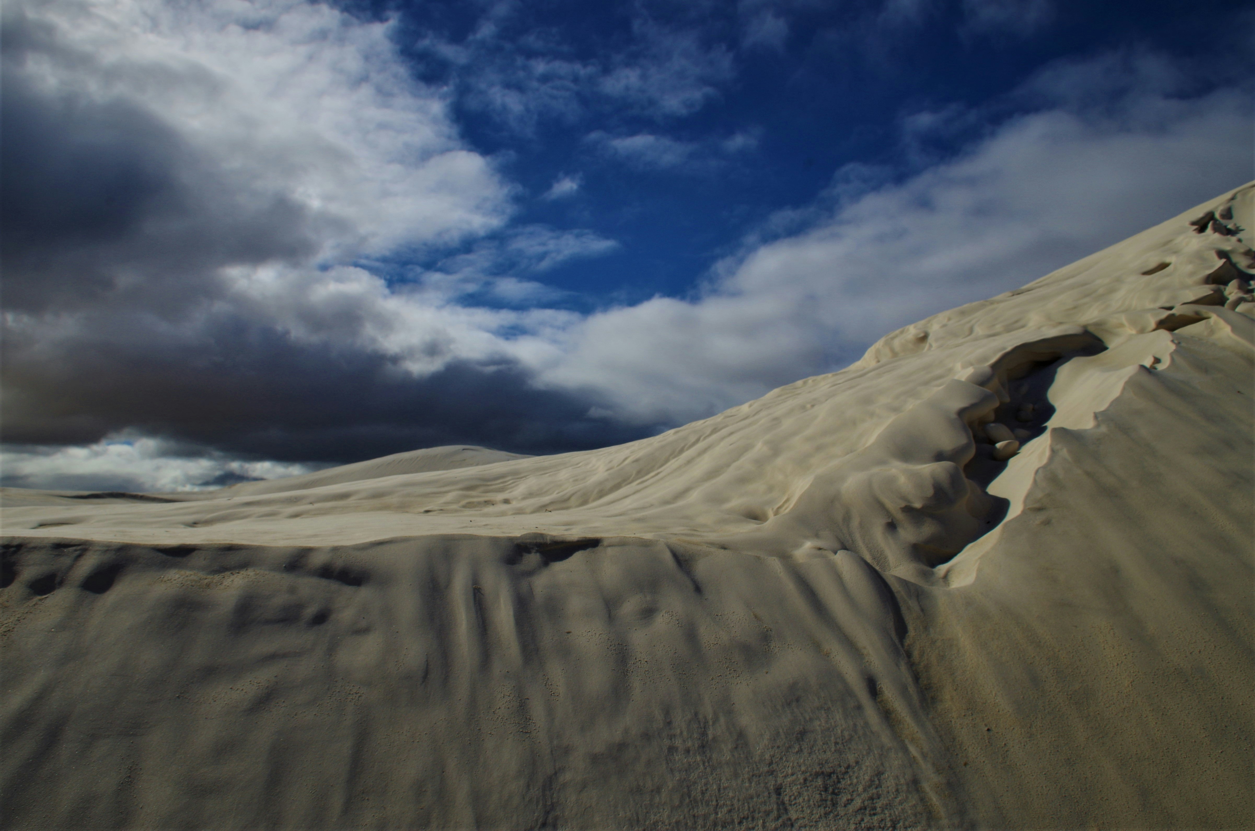 a large sand dune with clouds in the background, Nambung National Park is a national park in the Wheatbelt region of Western Australia, 200 km northwest of Perth, Australia and 17 km south of the small coastal town of Cervantes