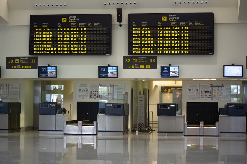 an airport terminal with a lot of electronic screens