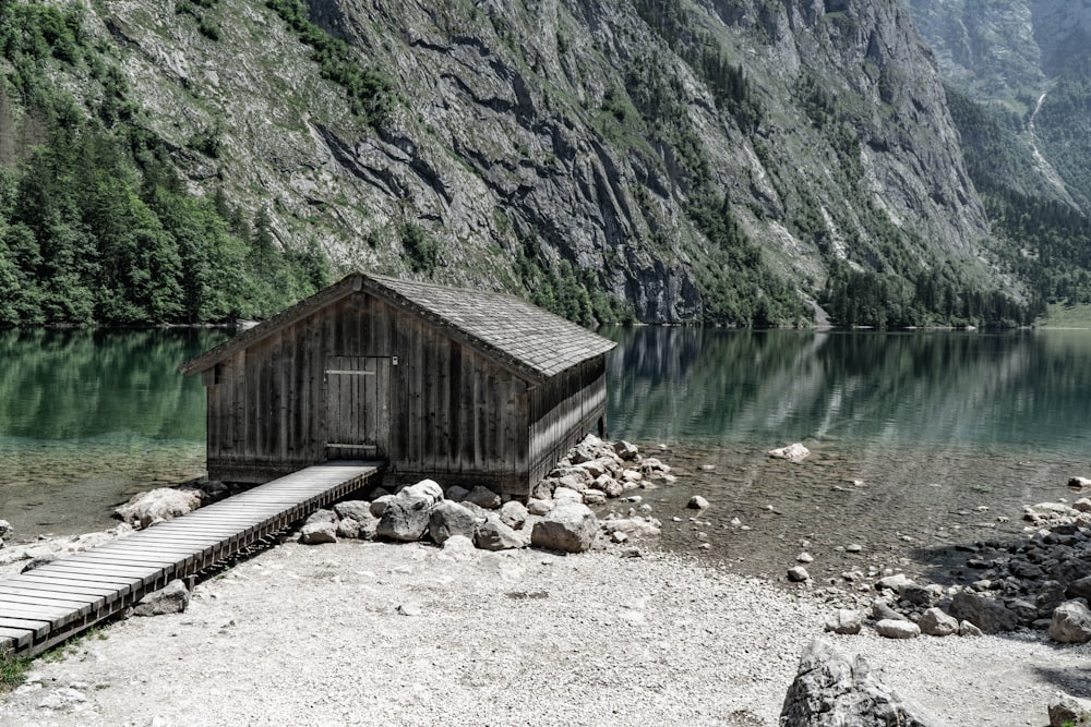 a small cabin on the shore of a mountain lake