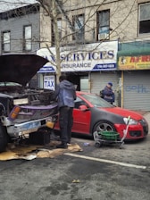 A mechanic helping a driver with a car engine issue beside a busy Indian highway.