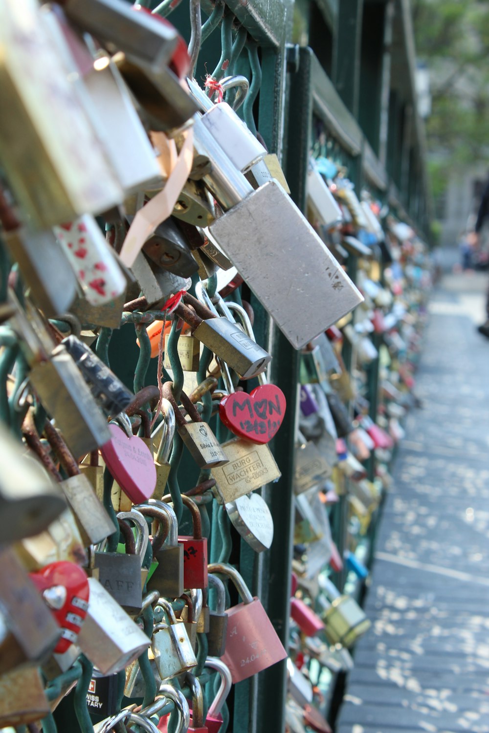 many padlocks are attached to a fence