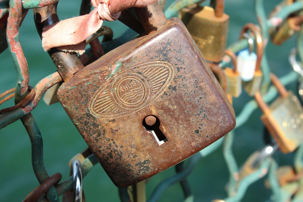 a close up of a padlock on a chain link fence