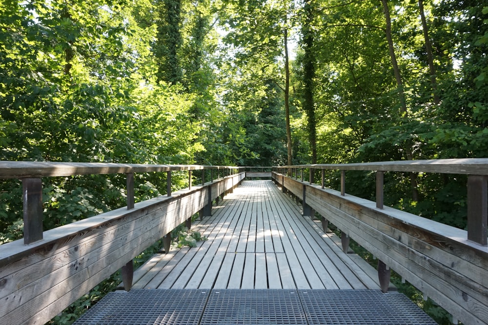 a wooden bridge surrounded by trees in a forest