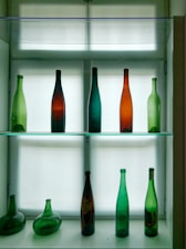 a glass shelf filled with lots of different colored bottles