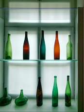 a glass shelf filled with lots of different colored bottles