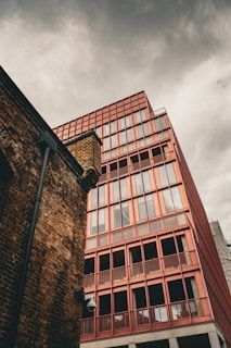 a tall red brick building next to a tall red brick building
