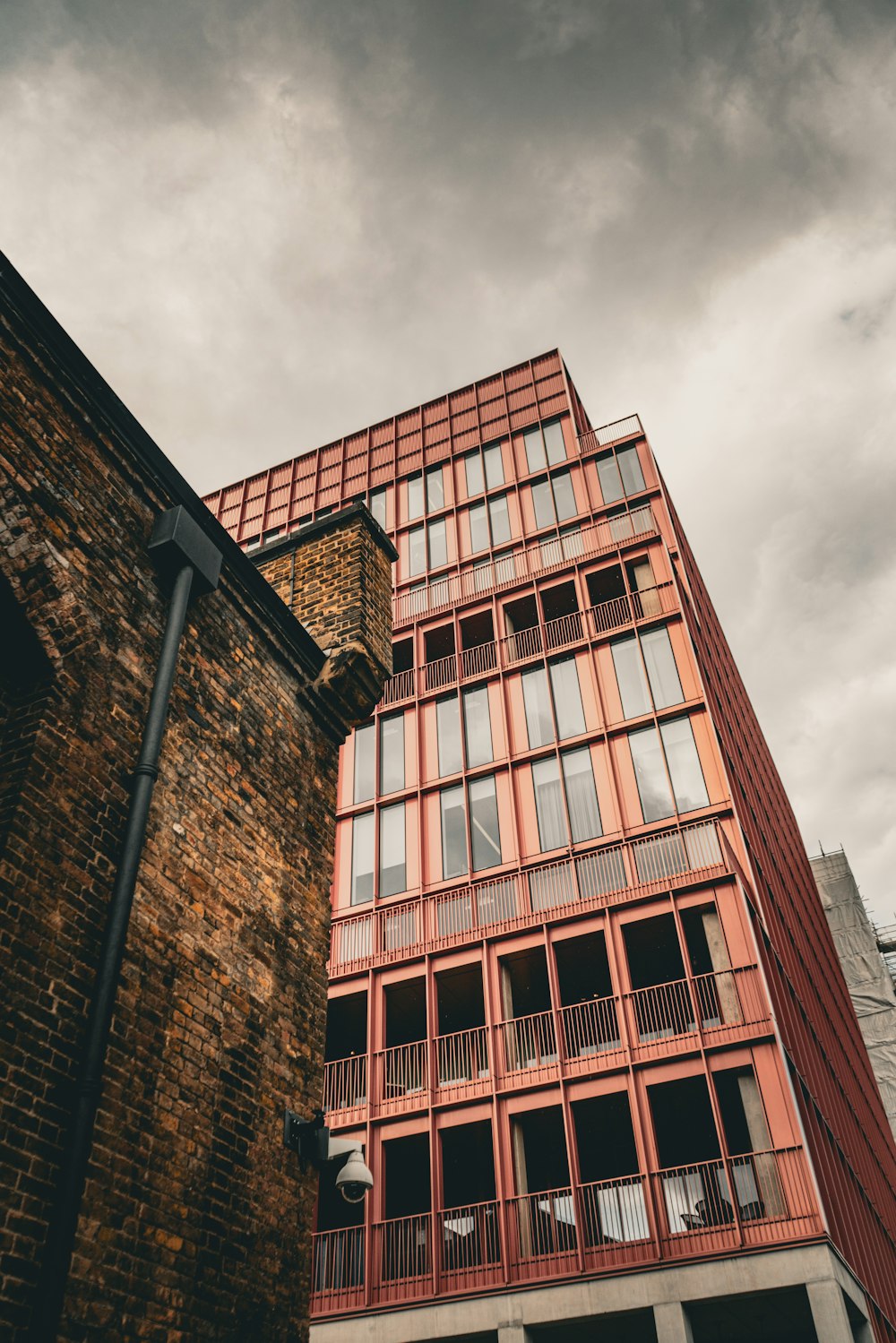 a tall red brick building next to a tall red brick building
