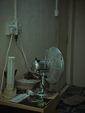 Close-up of drying fans and dehumidifiers working inside a water-damaged living room.