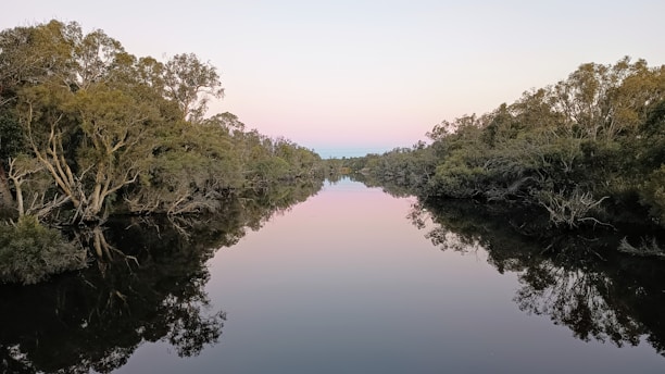 A serene sunrise over a tranquil river, symbolizing the sacred gift of life and divine grace.