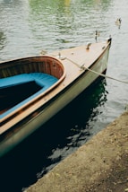 a small wooden boat tied to a dock