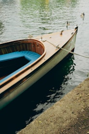 a small wooden boat tied to a dock